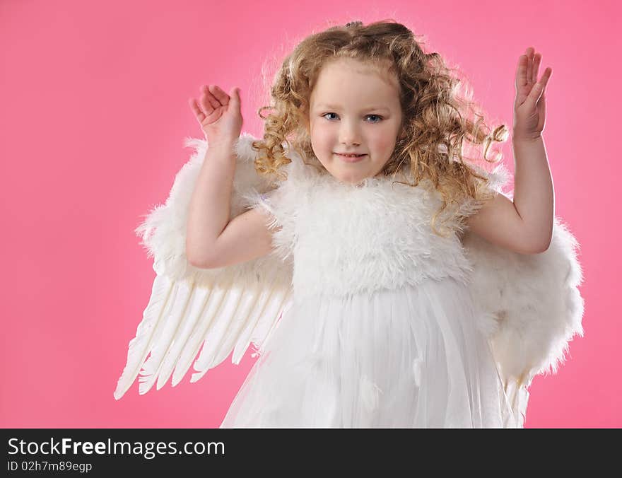 Beautiful little angel girl isolated on pink background