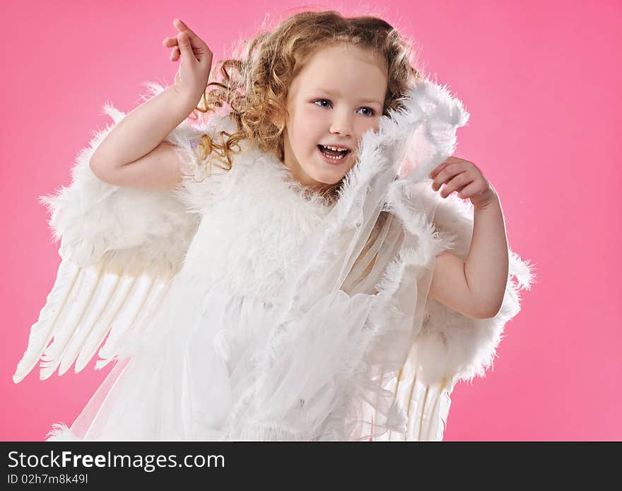 Beautiful little angel girl isolated on pink background