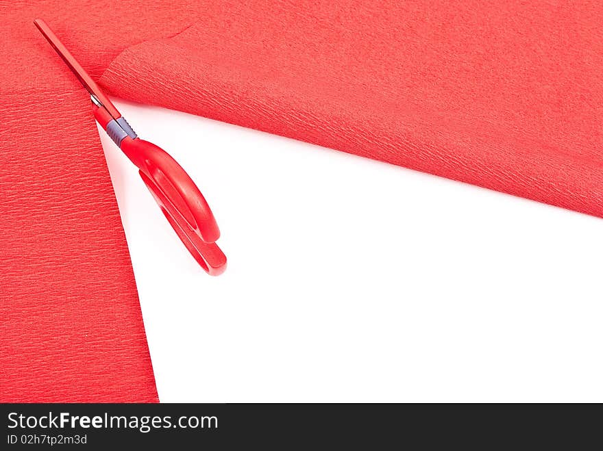 Scissors cutting red paper