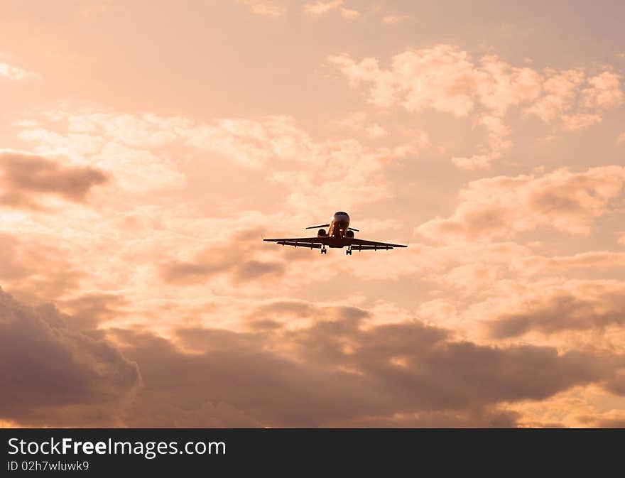 Landing aircraft on cloudy sky at sunset. Landing aircraft on cloudy sky at sunset