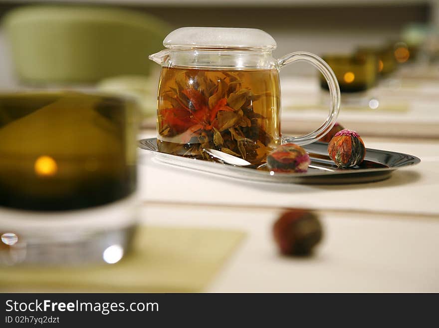 Glass tea pot with fresh green tea standing on an iron tray horizontal