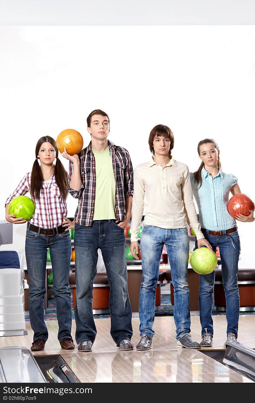 Four young people with spheres in bowling. Four young people with spheres in bowling