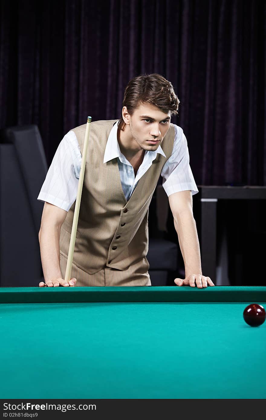 The young attractive man plays billiards. The young attractive man plays billiards