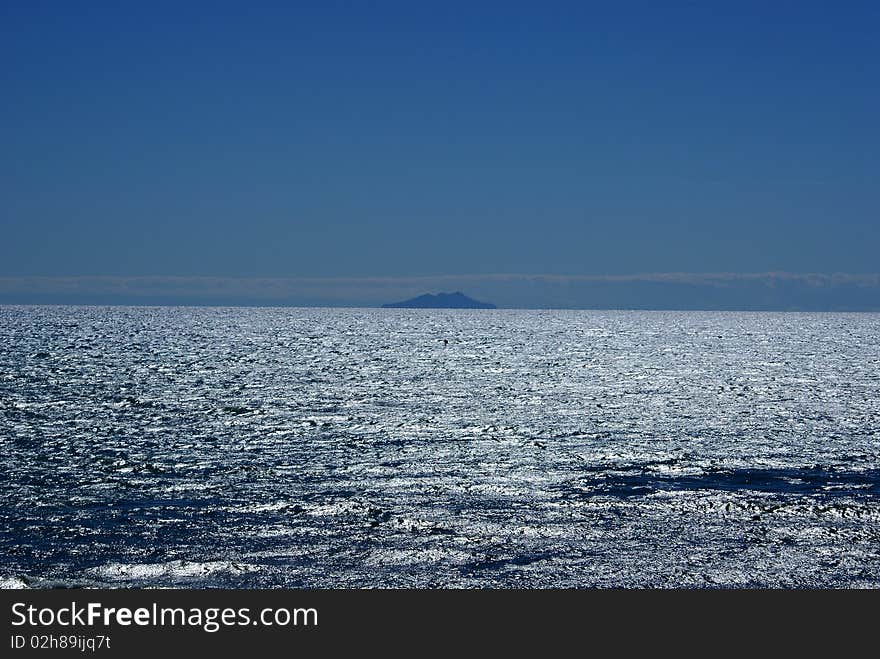 Giglio Island looks like a mirage on the horizon, in the Tyrrhenian Sea. Giglio Island looks like a mirage on the horizon, in the Tyrrhenian Sea.