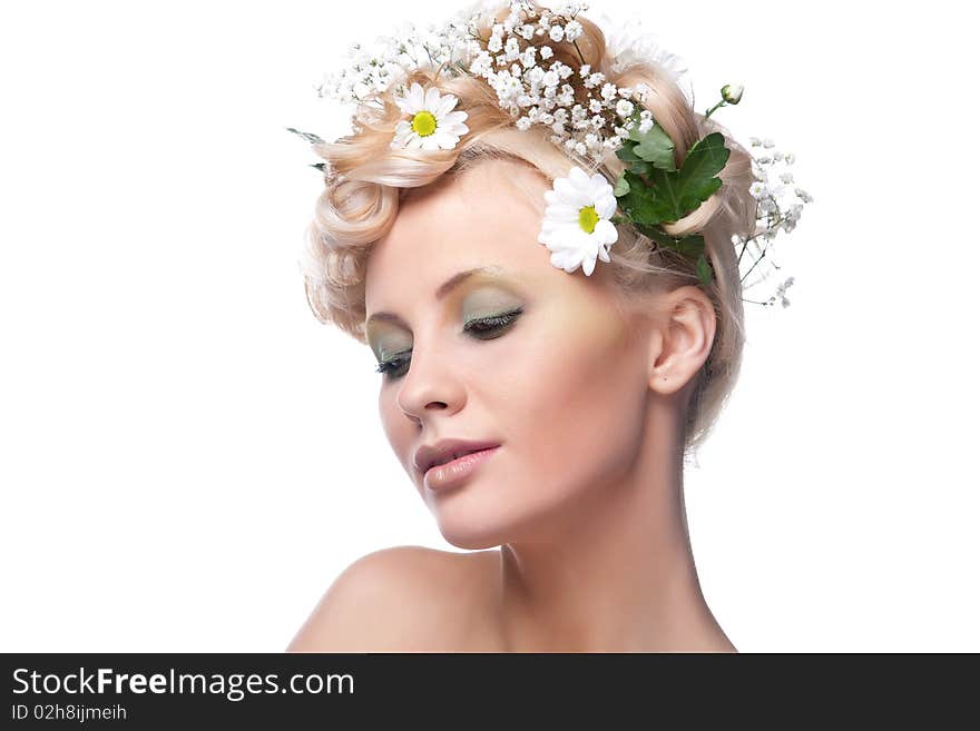 Beautiful young woman with fresh spring flowers in her hair