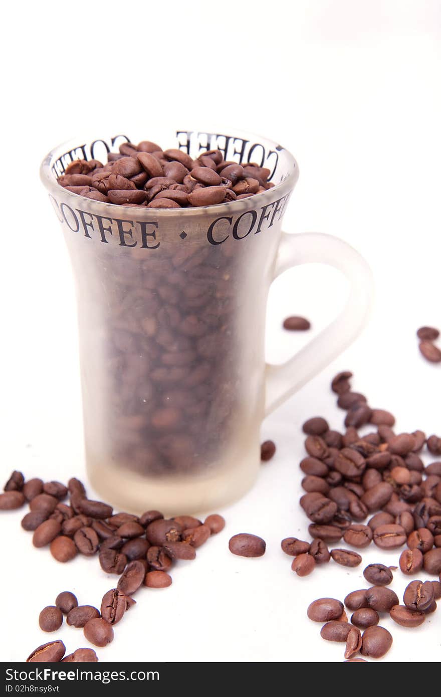 Cup with coffee beans over white background