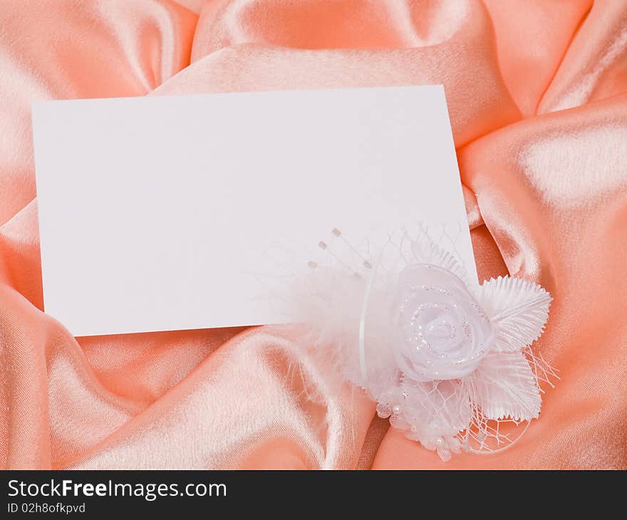 White card for congratulation, flowers from silk on a background from pink silk