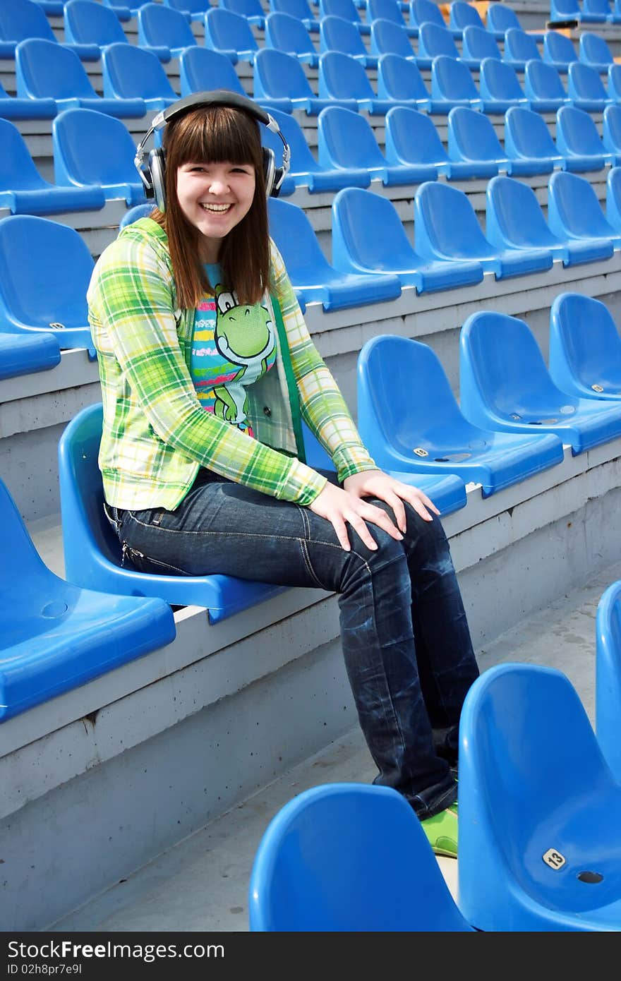 Smiling teen at the stadium with earphones