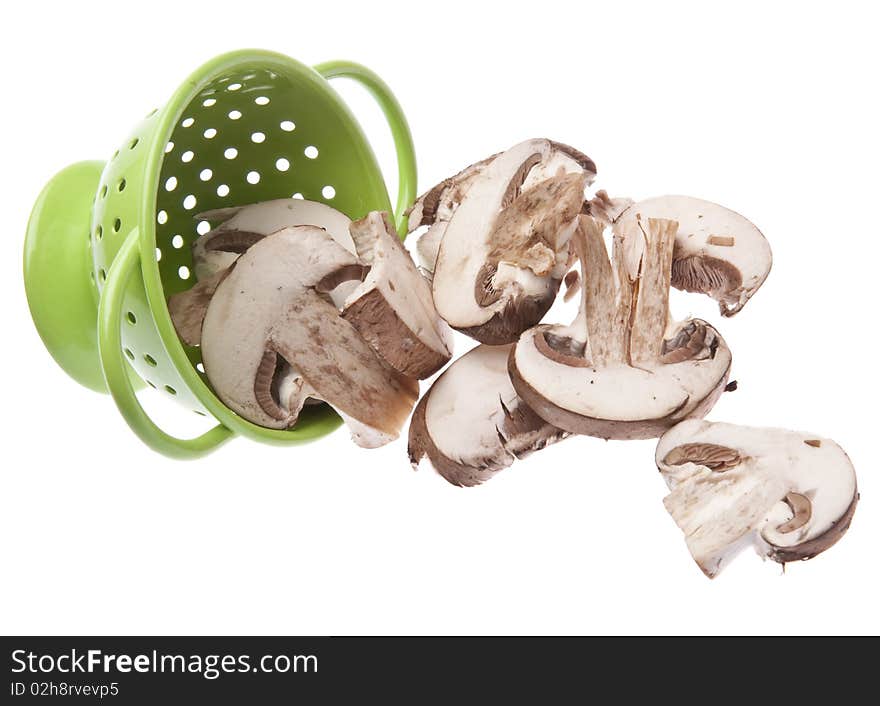 Fresh Mushroom Slices in a Vibrant Green Colander Isolated on White with a Clipping Path.