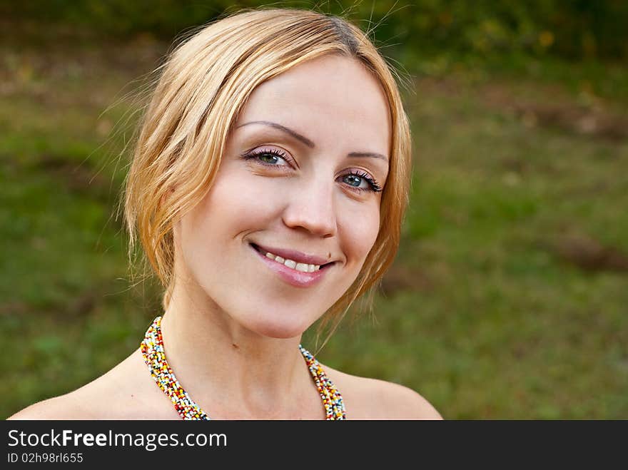 Pregnant woman on a grass and smiling