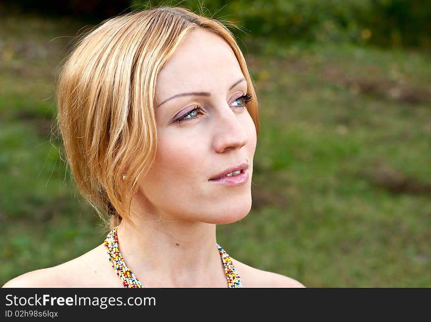 Pregnant woman on a grass and smiling