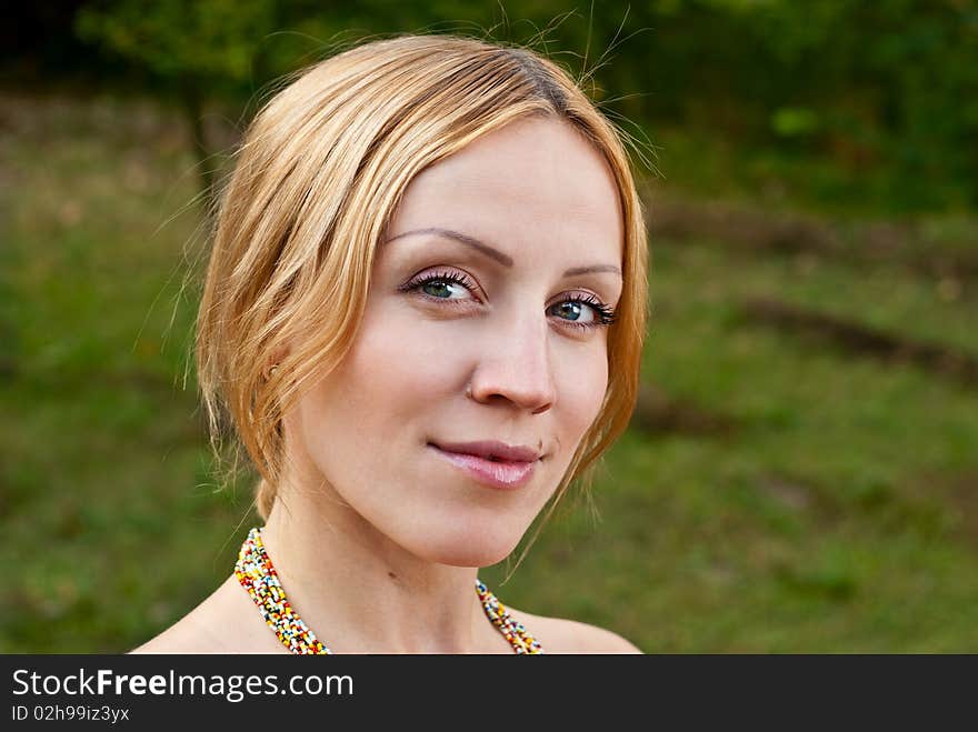 Pregnant woman on a grass and smiling