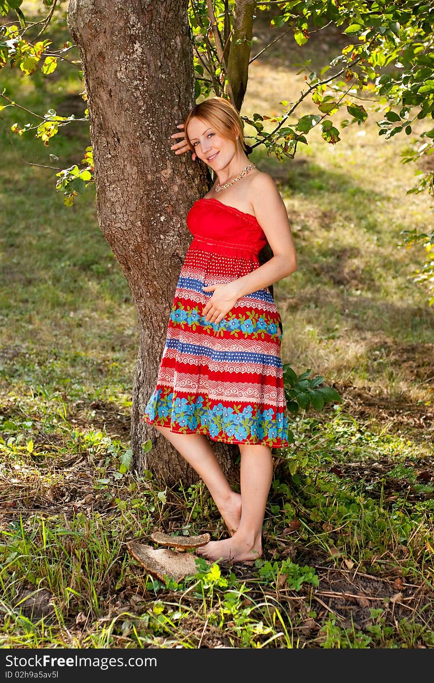 Pregnant woman on a grass and smiling