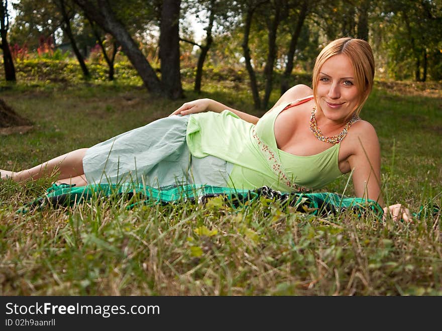 Pregnant woman on a grass and smiling