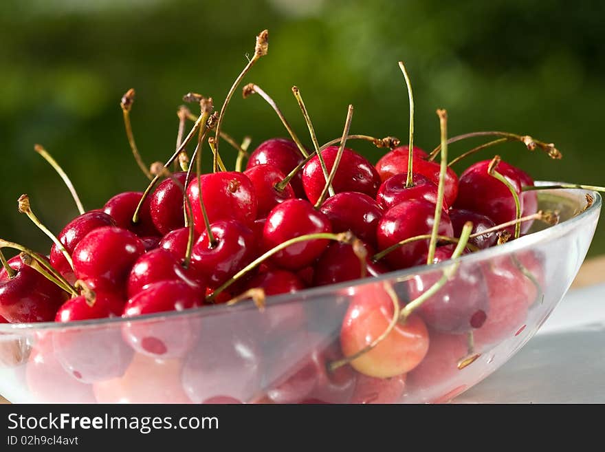 Food series: red ripe cherries on glassy plate. Food series: red ripe cherries on glassy plate