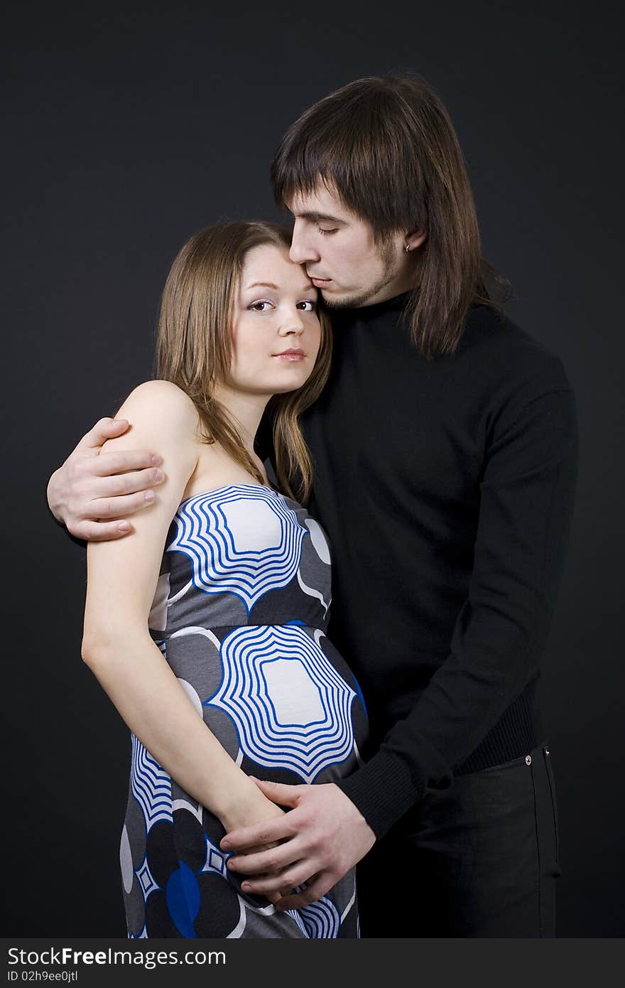 Pregnant couple in loving pose.