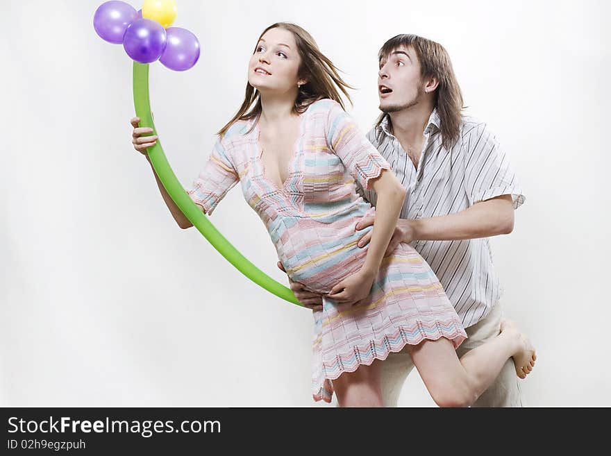 Happy flying pregnant couple holding balloon