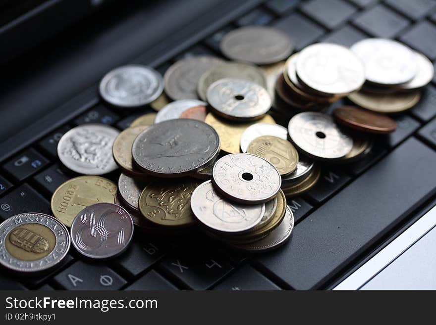 A shot of a laptop and world coins