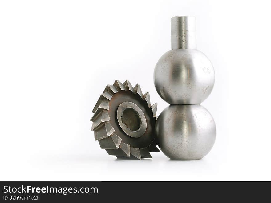 Some kind of metallic cutter, near two metallic balls sitting on eachother, isolated on white background. Some kind of metallic cutter, near two metallic balls sitting on eachother, isolated on white background