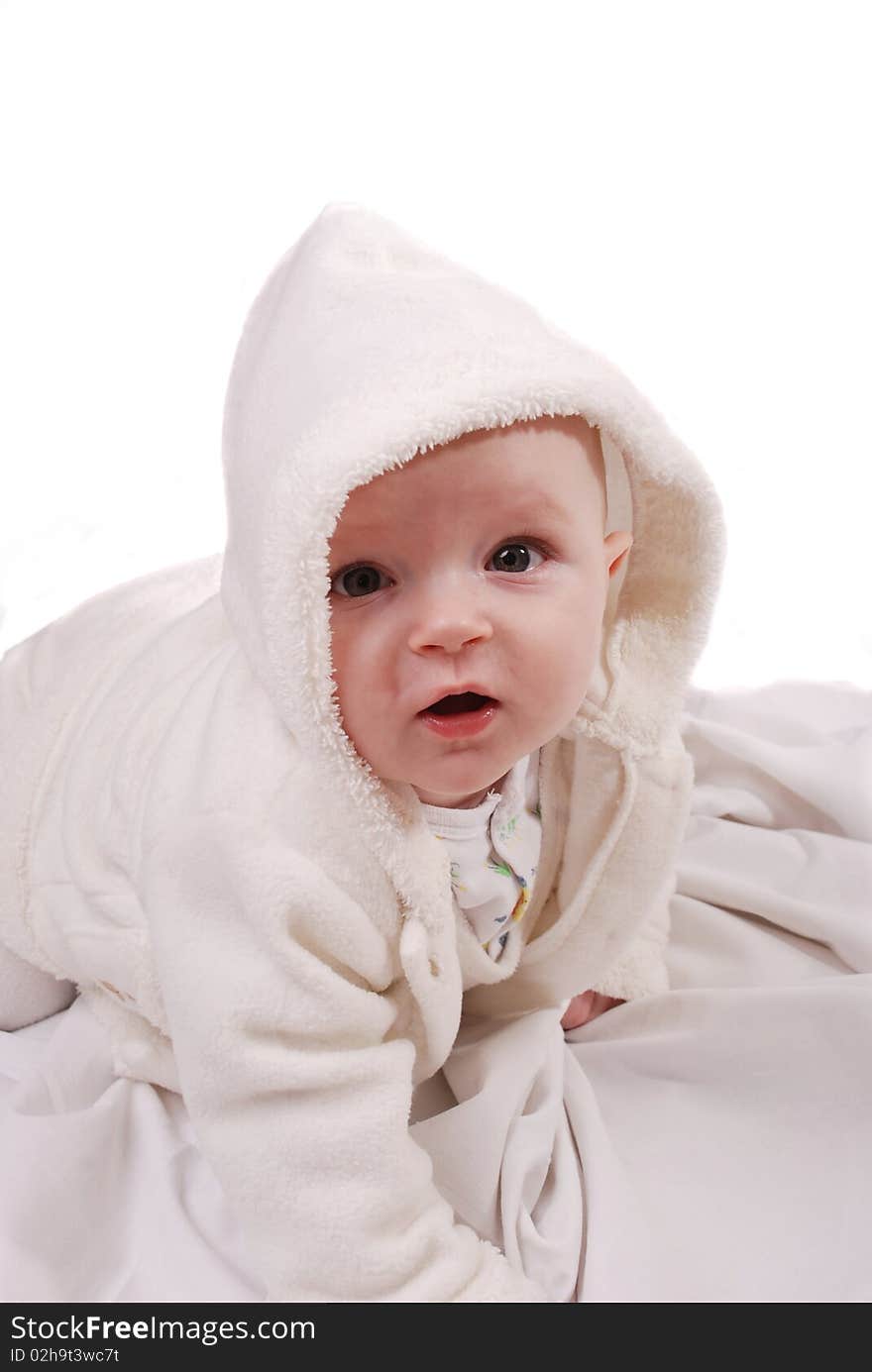 Beautiful baby girl in bathrobe on white background