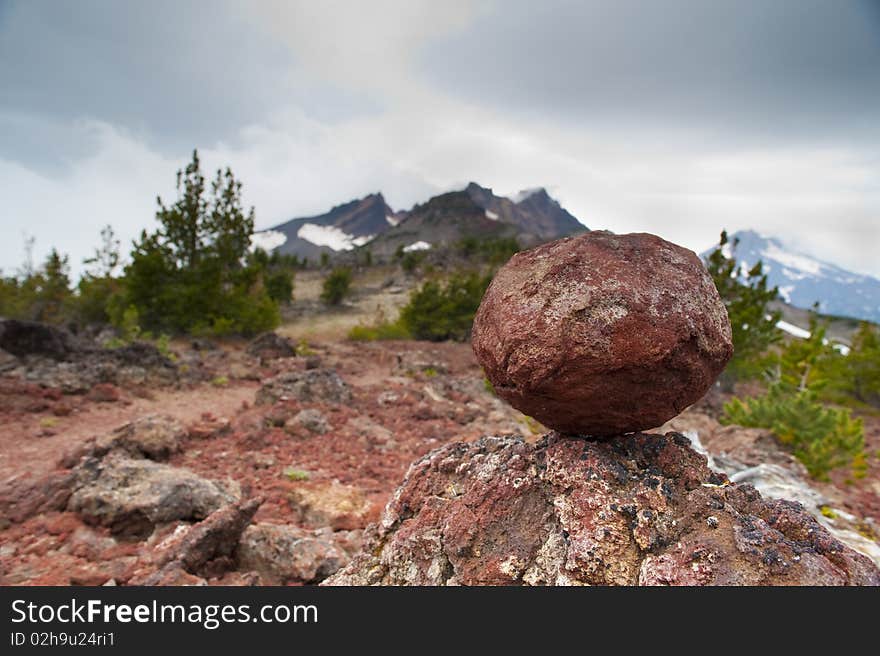 Red rock balancing on another rock, Broken Top mountain. Red rock balancing on another rock, Broken Top mountain