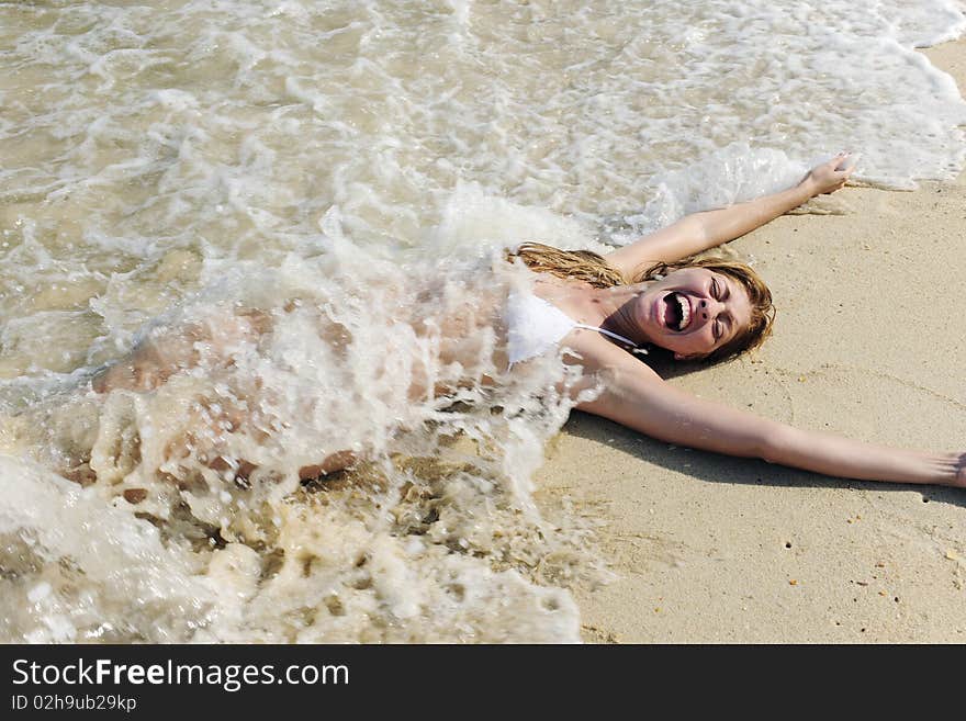 Sexy woman splashed by wave on the beach