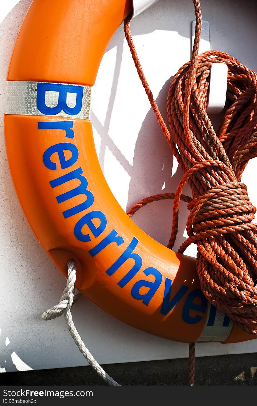 Close up of a orange lifebelt whit orange rope on a wall