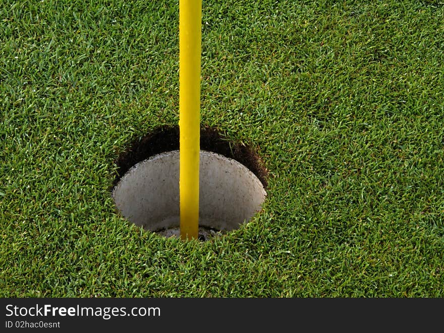 Golf course hole with yellow flagpole. Golf course hole with yellow flagpole