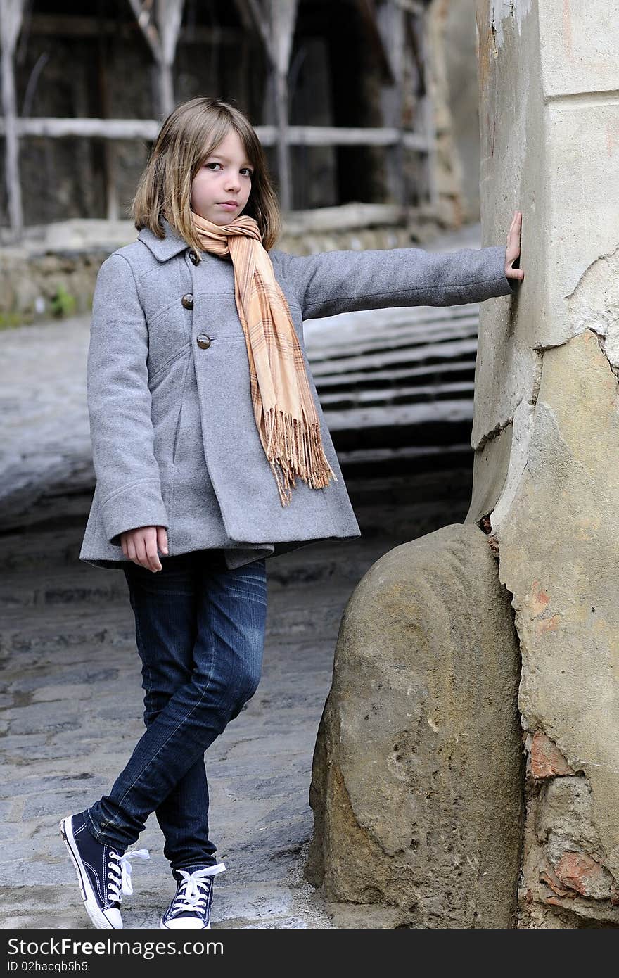 White child standing near ruins in old city. White child standing near ruins in old city