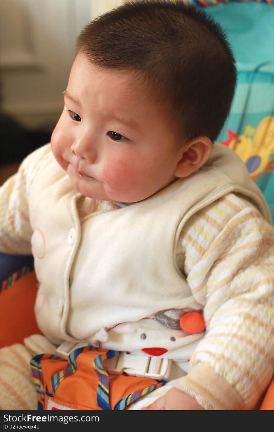 Lovely Chinese baby sitting on a chair. Lovely Chinese baby sitting on a chair