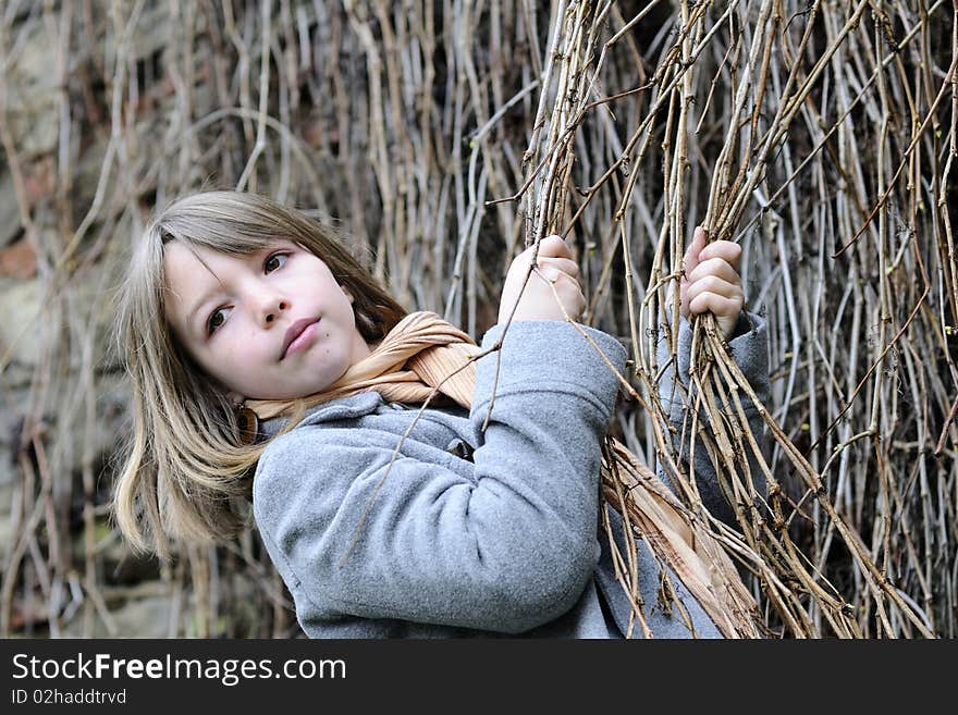 White child having fun with vegetation, old wall in background. White child having fun with vegetation, old wall in background