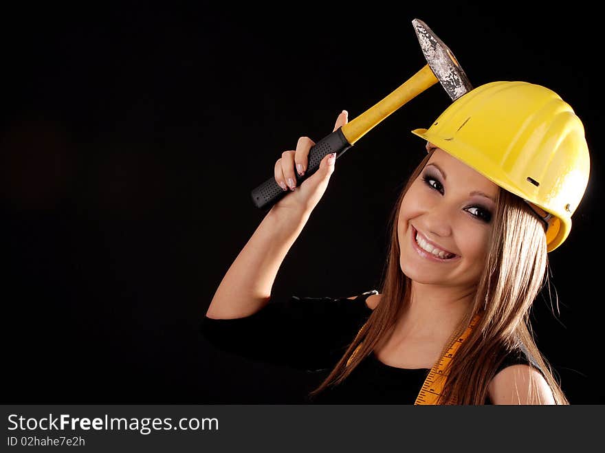 Builder girl with a hammer in hand, helmet on head. Builder girl with a hammer in hand, helmet on head.