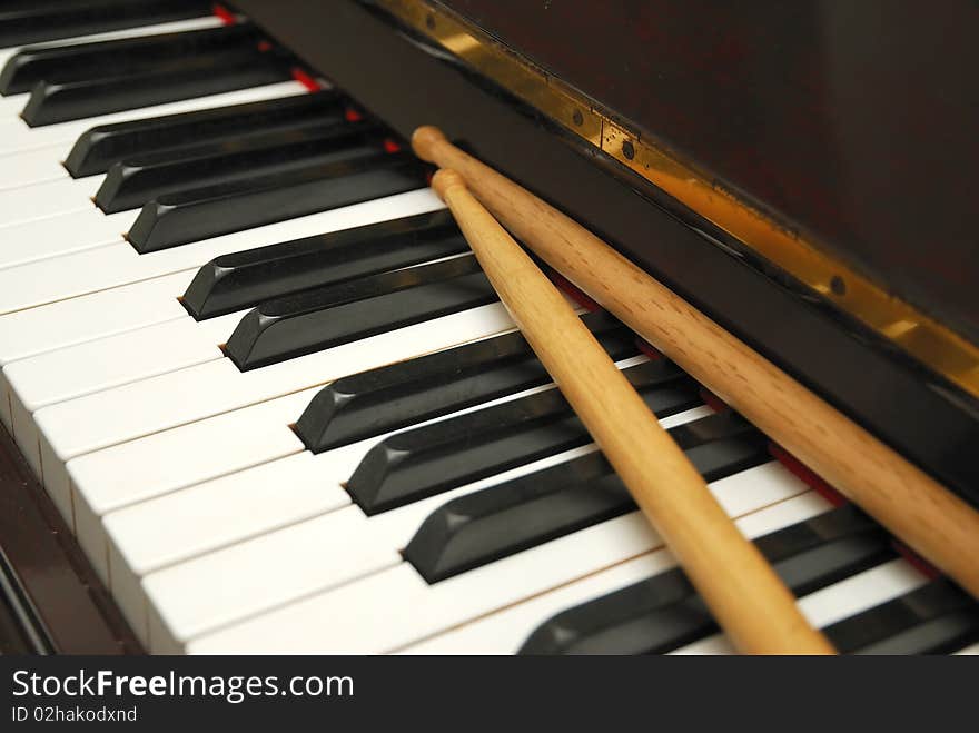 Diagonal Shot Of Drum Sticks On Piano Keyboard