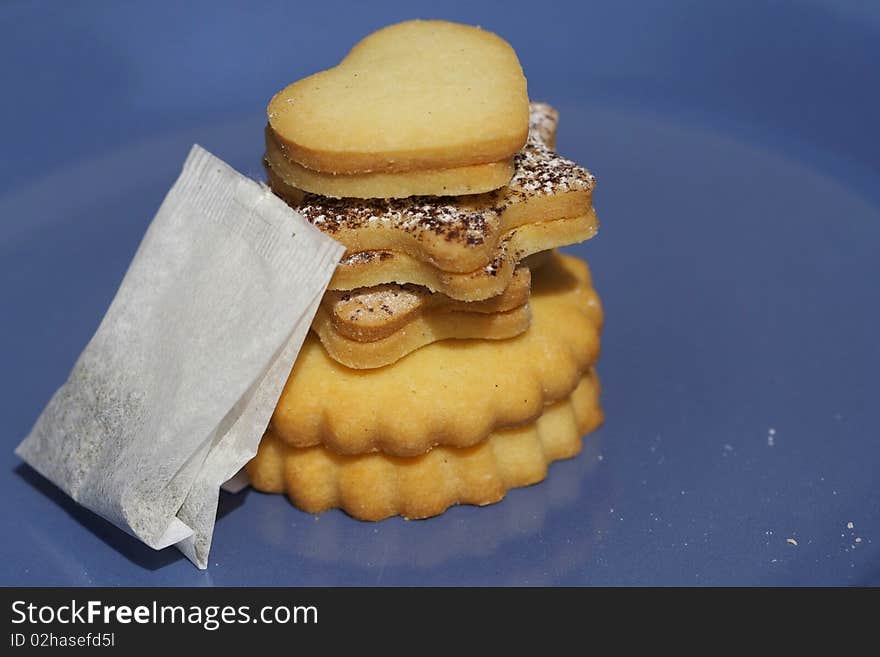 Assortment at fresh pastries with tea, against a blue background. Assortment at fresh pastries with tea, against a blue background