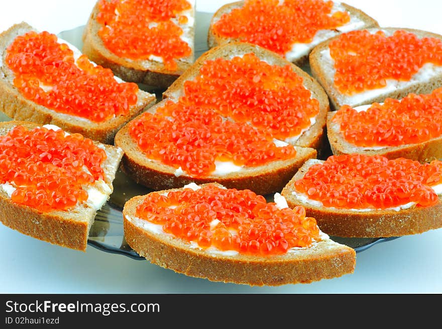 Bread with butter and red caviar on a plate. Bread with butter and red caviar on a plate