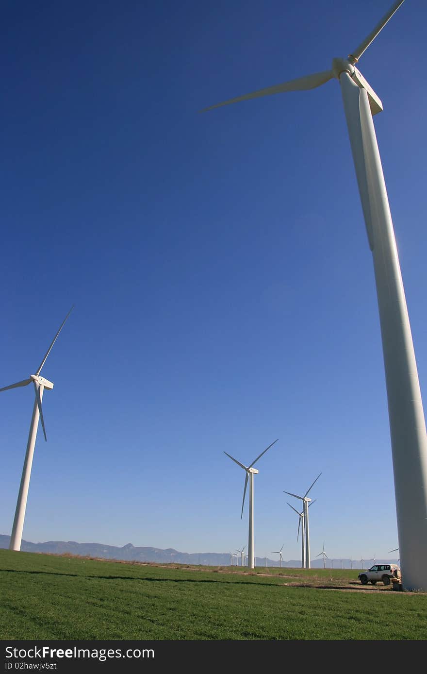 Row of six wind turbines in front of mountains