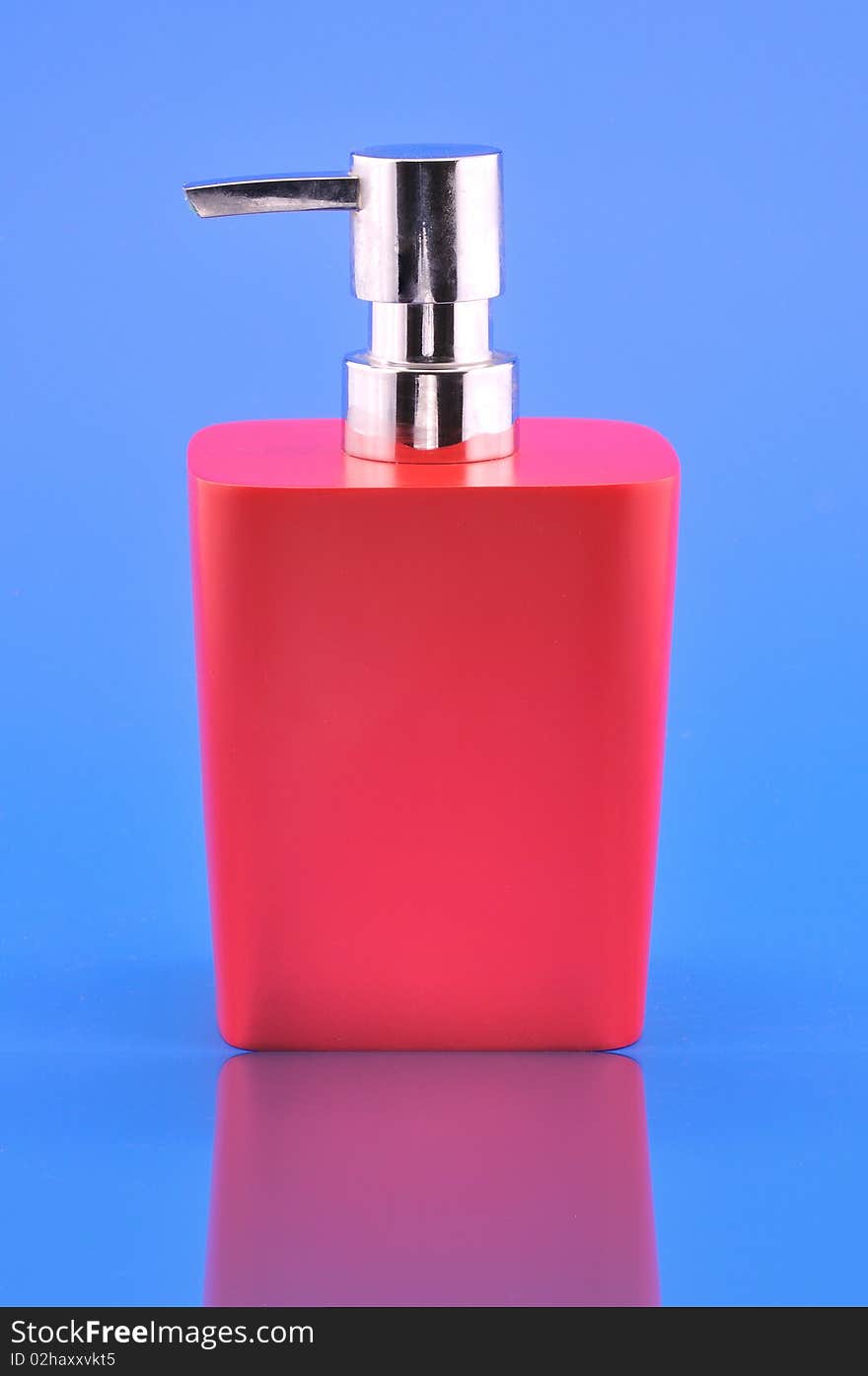 Dispenser red photographed on a blue background with reflection