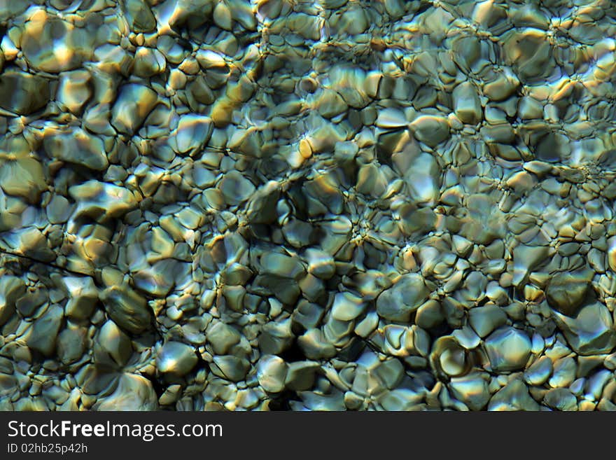 Colorful stones under water, with water effect over them. Colorful stones under water, with water effect over them