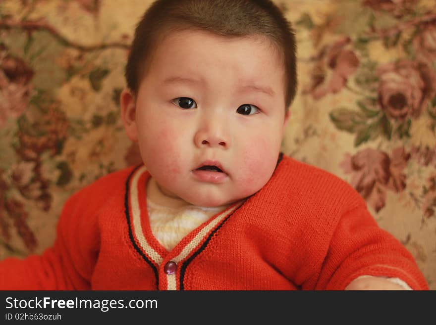 Lovely Chinese baby sitting on a chair. Lovely Chinese baby sitting on a chair