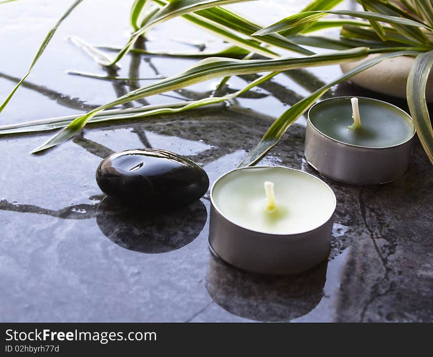 Spa candles on dark wet background. Spa candles on dark wet background