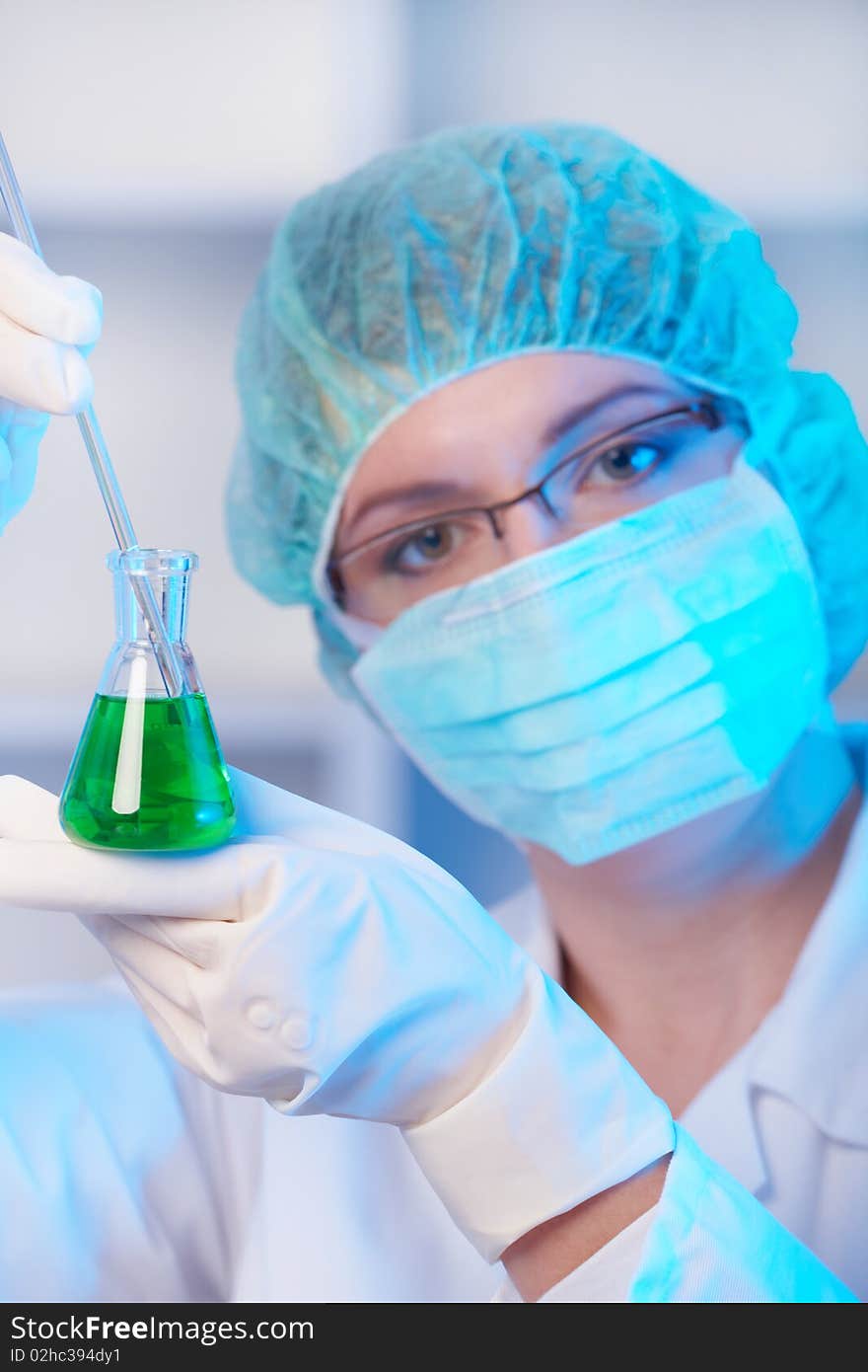 Closeup of a female researcher holding up a test tube and a retort in the laboratory