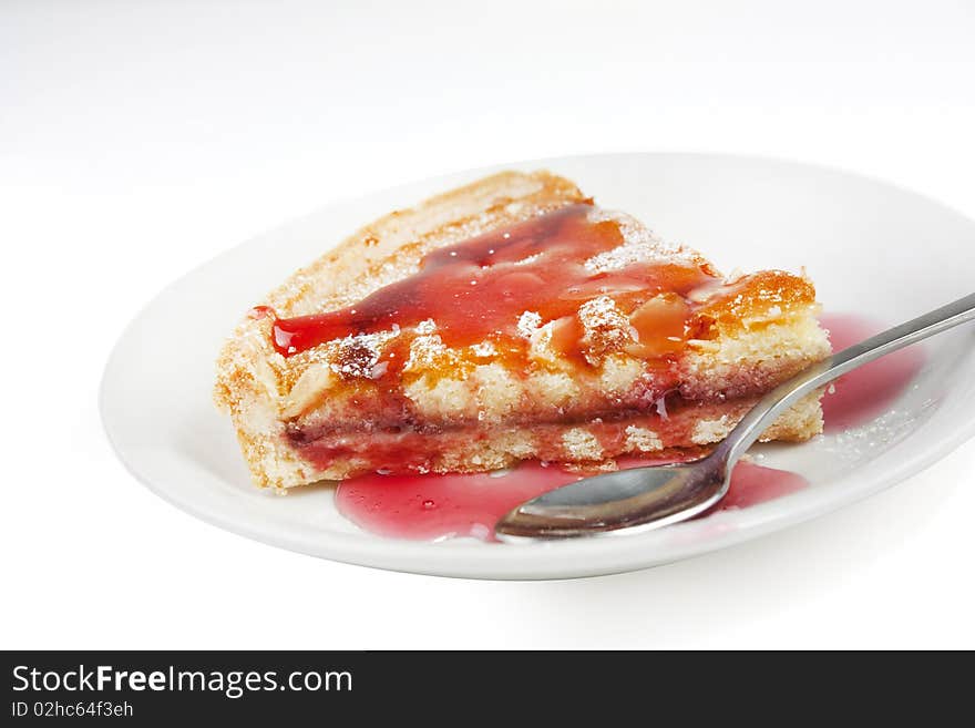 Bakewell tart with raspberry sauce isolated on white. Bakewell tart with raspberry sauce isolated on white