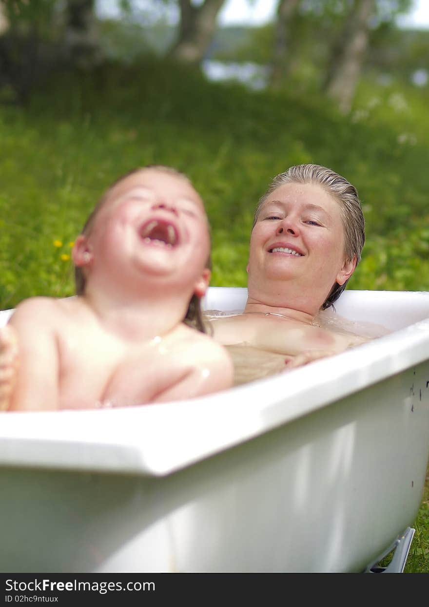 Mother and daughter taking a hot bath outdoor. Mother and daughter taking a hot bath outdoor