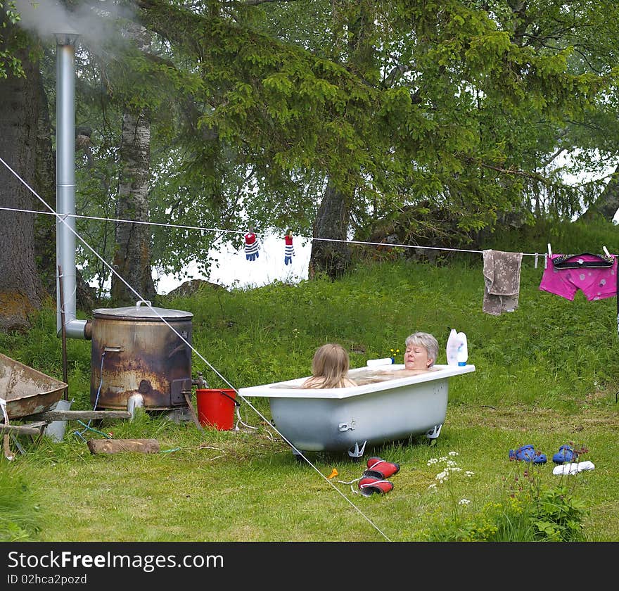 Mother and daughter taking a hot bath outdoor. Mother and daughter taking a hot bath outdoor