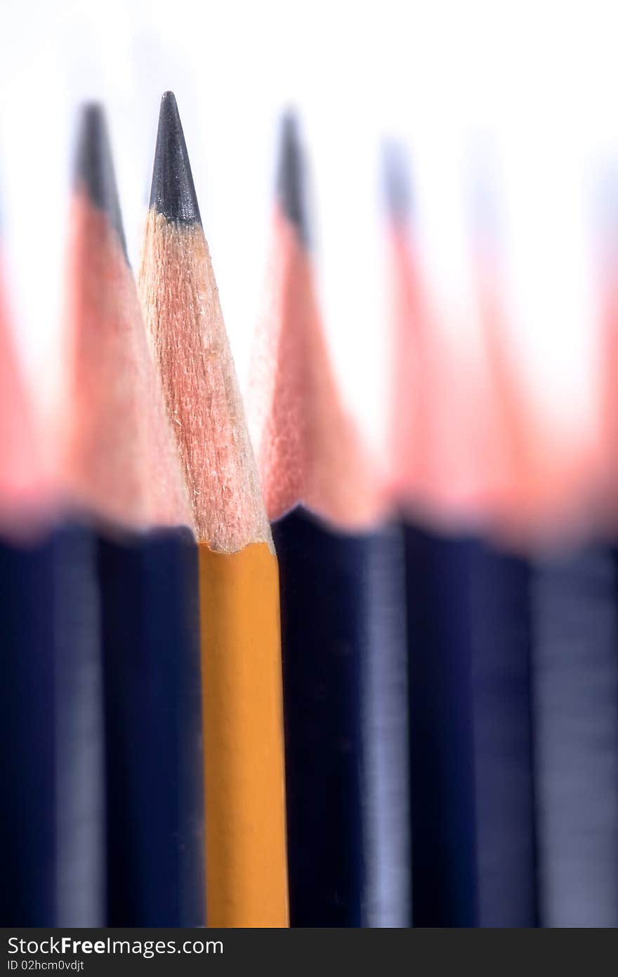 Yellow pencil in a row of blue pencils