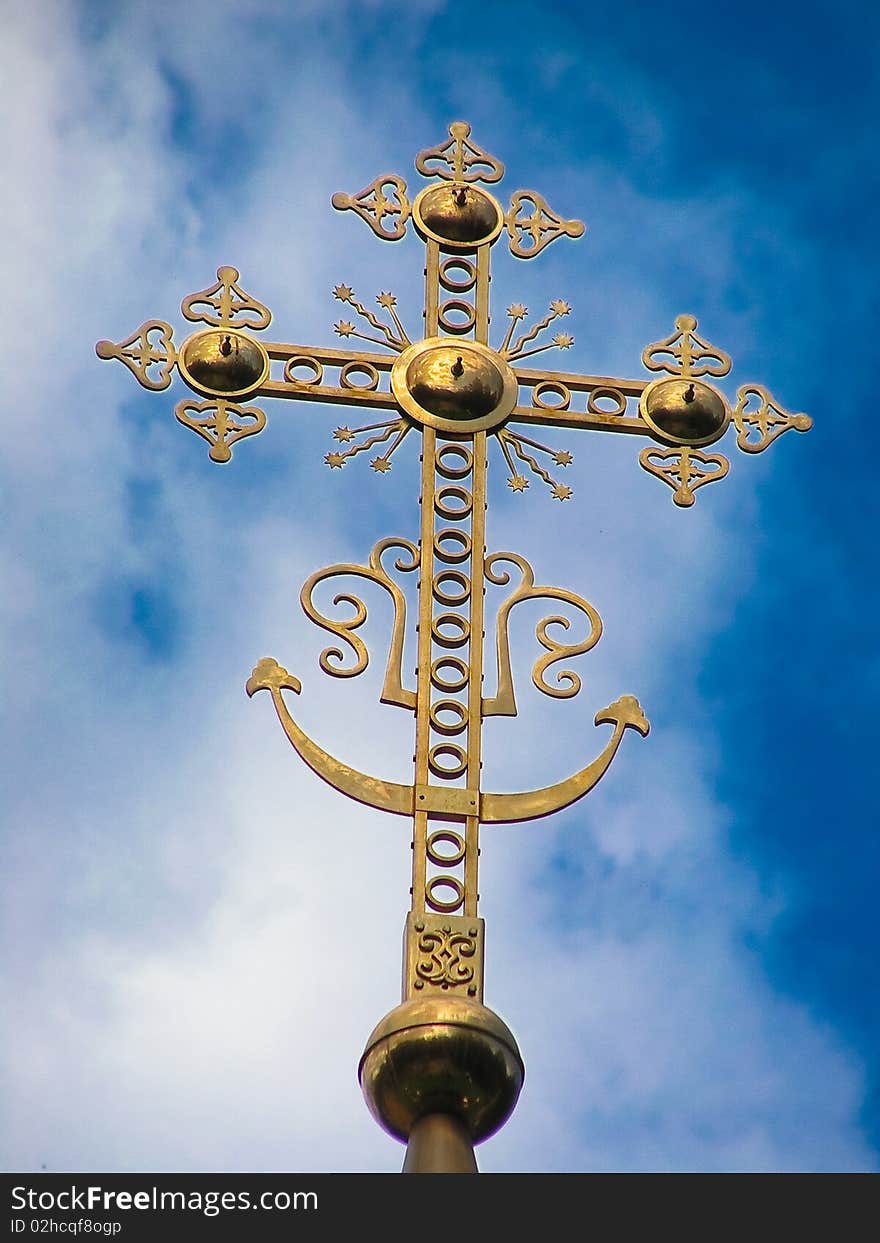 Golden cross over blue sky