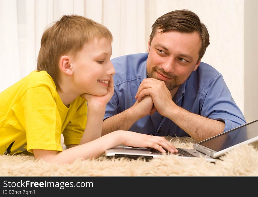 Father And Son On The Carpet With Laptop