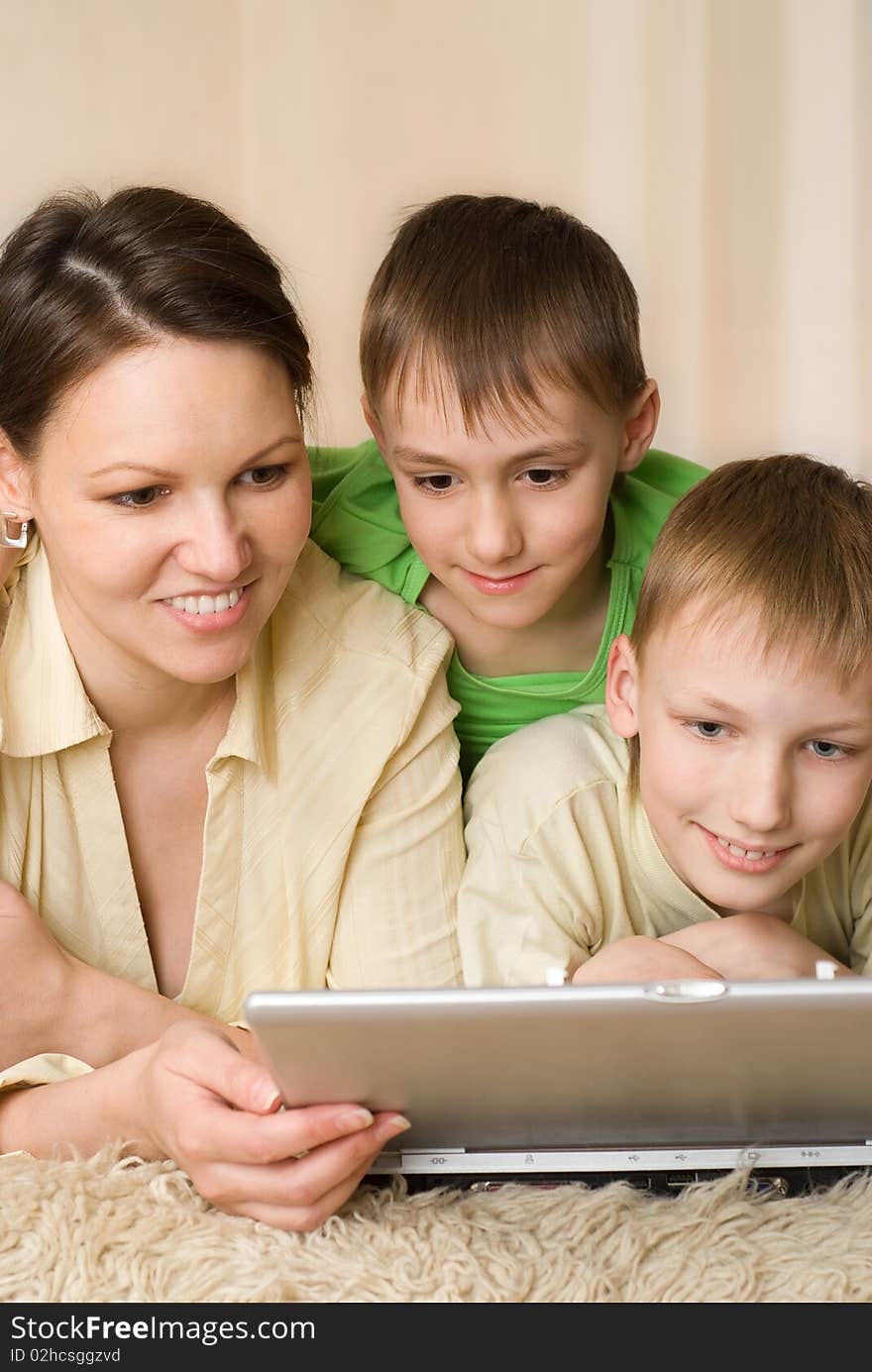 Happy mother with her children about looking at laptop