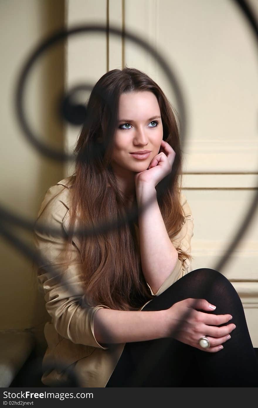 Beautiful brunett girl sitting behind fence