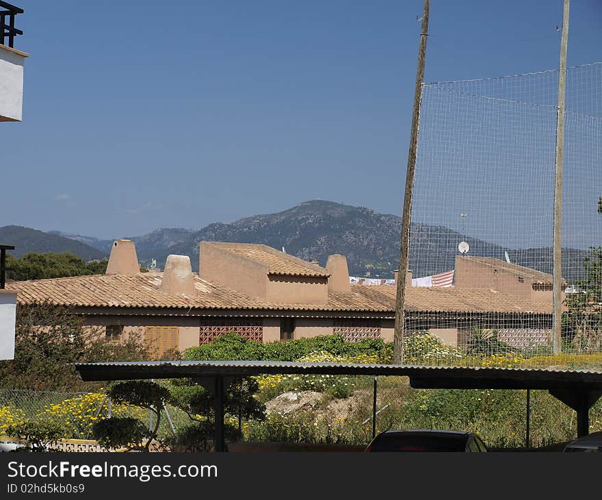 Picture depicts sun beaten house with mountain and heavily clear blue sky foreground. Picture depicts sun beaten house with mountain and heavily clear blue sky foreground